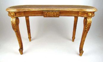 An early 20th century giltwood stool, the kidney shaped caned seat on acanthus carved cabriole