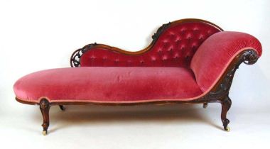 A Victorian walnut chaise lounge upholstered in a pink button back fabric, the carved foliate show