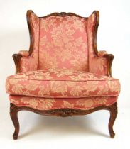 A reproduction 18th century French style walnut framed armchair upholstered in a floral patterned