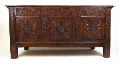 A late 17th century oak coffer, the top lifting to reveal a vacant interior over the three panel