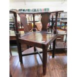 An 18th century pine, elm, oak and fruitwood corner chair, the yoke arms over shaped splats and