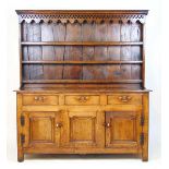 An early 18th century oak dresser, the plate rack with a cavetto cornice over a pierced and shaped