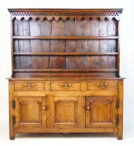 An early 18th century oak dresser, the plate rack with a cavetto cornice over a pierced and shaped