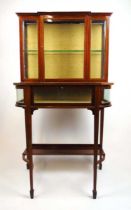 An Edwardian mahogany and boxwood strung display cabinet, the glazed breakfront top over the