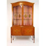 An early 20th century satinwood and painted display cabinet, the dome top over two glazed doors with