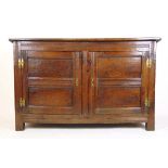 A late 17th century oak two door cupboard, the cleated top over the moulded frame and two twin panel