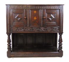 A 17th century and later oak side cupboard, the top over two cupboard doors flanking a marquetry