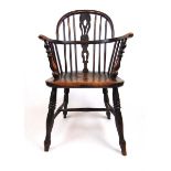 An early 19th century elm and beech Windsor chair, the spindle back over a shaped seat on turned