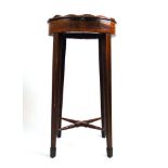 A late 18th century mahogany and boxwood strung kettle stand, the oval galleried top over the