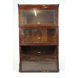 An early 20th century oak sectional bookcase by Globe-Wernicke & Co., comprising of plinth and