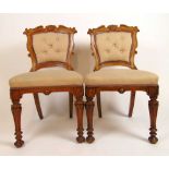 A pair of 19th century oak dining chairs upholstered in a patterned beige fabric, the carved and