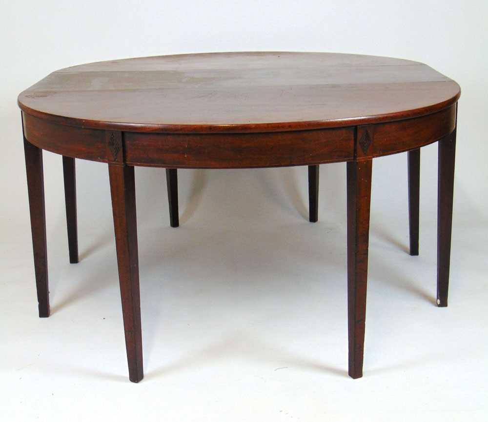 An early 19th century mahogany and boxwood strung dining table, the two D-ends with extra central