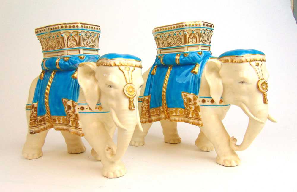 A pair of 19th century Royal Worcester vases in the form of elephants carrying howdahs, glazed in