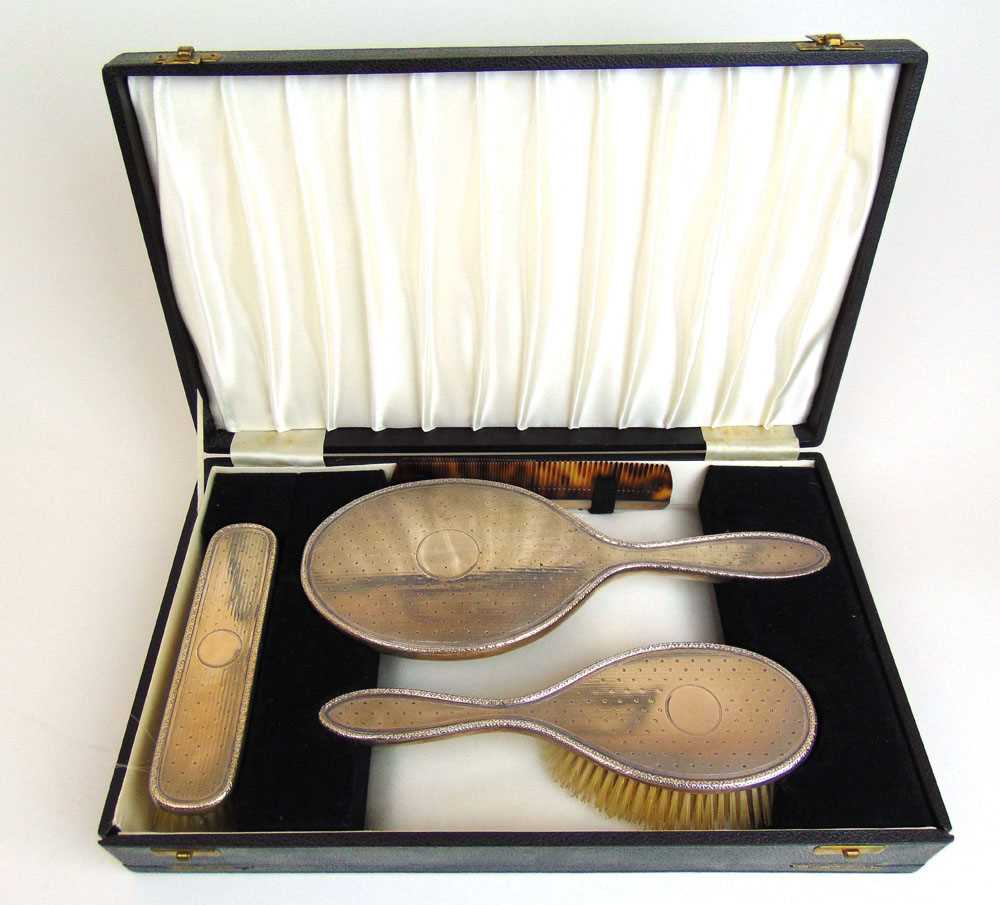 A cased George V silver four piece dressing table set. Hallmarked for Birmingham 1918, maker's