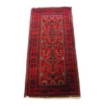 A handwoven Persian rug, the multi line border surrounding a red ground field with geometric and