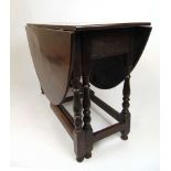 An early 18th century oak gate leg table base, the later drop leaf top supported on a single gate