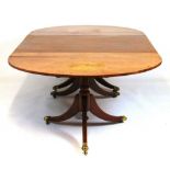 An early 19th century mahogany three pod dining table, the inlaid top with one extra leaf on the