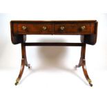 A Regency mahogany and ebony strung sofa table, the drop leaf top over two drawers on end supports