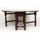 A late 17th/early 18th century oak gate leg dining table, the drop leaf top supported on a single