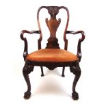 An early 20th century walnut open armchair in the 18th century style, the carved top rail and