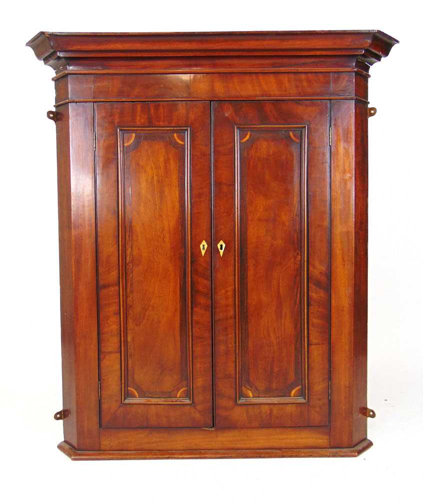 An 18th century mahogany and rosewood banded wall hanging corner cupboard, the cavetto cornice