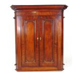 An 18th century mahogany and rosewood banded wall hanging corner cupboard, the cavetto cornice
