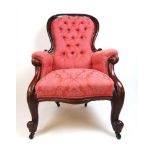 A Victorian mahogany nursing chair upholstered in a floral patterned pink button back fabric, the