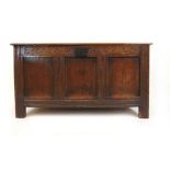 An early 18th century oak coffer, the top lifting to reveal a vacant interior over the three panel
