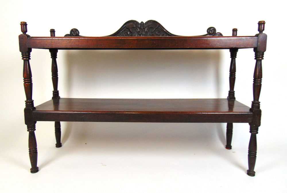 A 19th century oak two tier buffet, the mythical creature carved back above the two shelves