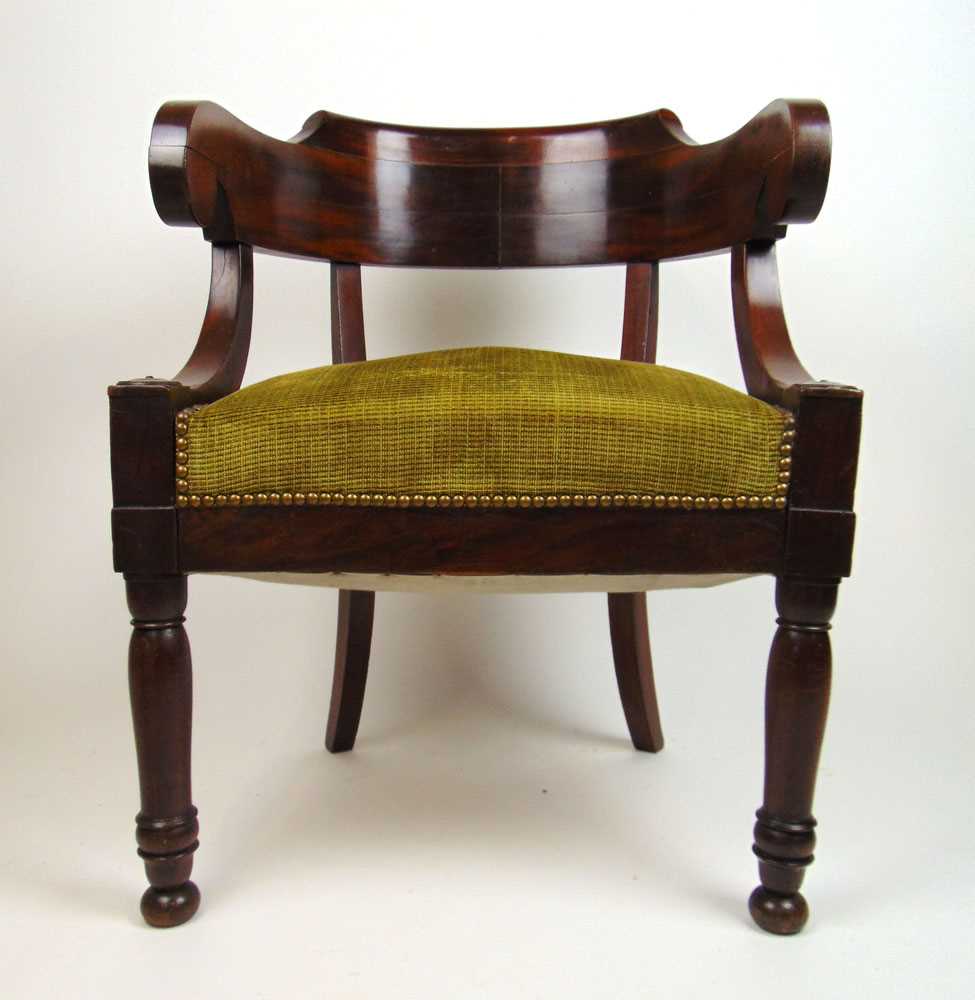 An early 19th century mahogany tub chair, the curved back supported on C-scrolls over the seat