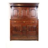 An 18th century oak deuddarn, the cornice over three arch top field panel doors on the base with