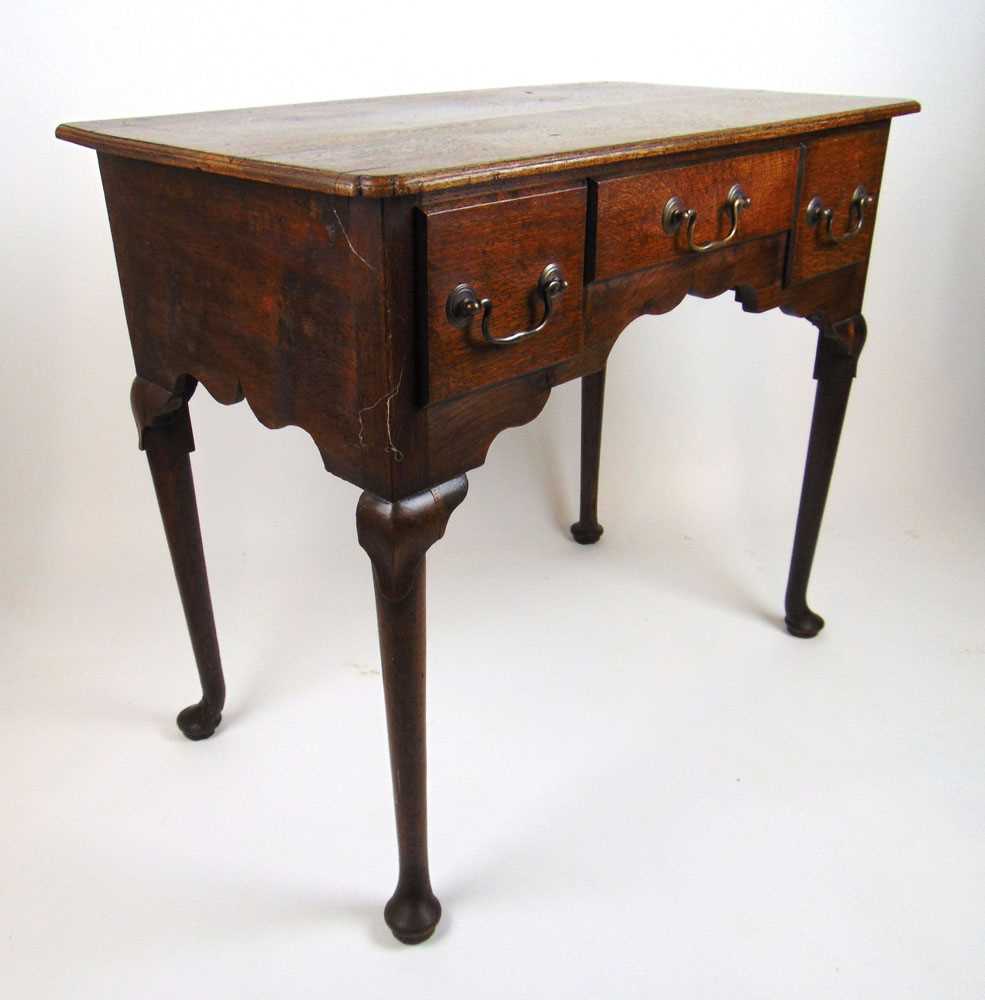 A mid 18th century oak lowboy, the moulded top with re-entrant corners over three drawers and a - Image 2 of 2