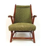 A late 19th century walnut framed open armchair upholstered in a patterned green fabric, the