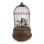 A late 19th/early 20th century brass bird cage automaton, the red and yellow plumed birds singing,