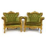 A pair of reproduction giltwood armchairs in the Baroque style upholstered in a button back cut