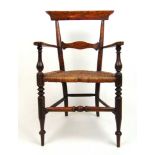 An early 19th century simulated rosewood childs armchair, the caned seat on turned legs and