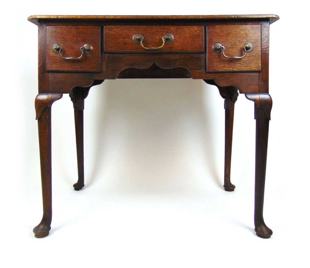 A mid 18th century oak lowboy, the moulded top with re-entrant corners over three drawers and a