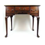 A mid 18th century oak lowboy, the moulded top with re-entrant corners over three drawers and a