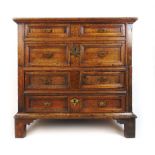 A late 17th century oak chest of four long drawers, the top over the moulded front drawers on