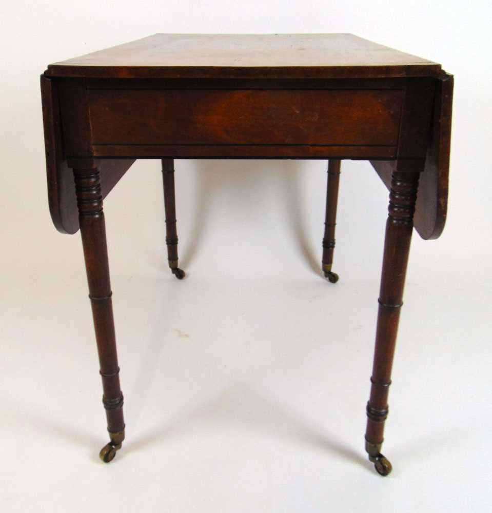 An early 19th century mahogany and ebony strung Pembroke table, the drop leaf top over single end