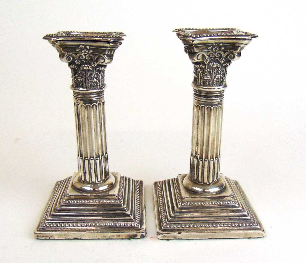 A pair of Edwardian silver Corinthian column candlesticks. Hallmarked for Birmingham 1907, makers