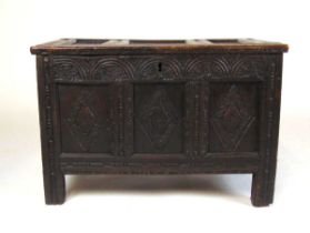 An 18th century oak blanket box, the top with three recessed panels, with carved arcaded frieze over