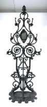 A Victorian style cast iron hall stand, of floral scroll form with hinged oval mirror and umbrella