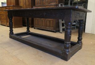 An 17th century and later joined oak refectory table, with five plank top above a carved frieze,