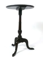 A George III mahogany occasional table, the circular one piece dish top on a turned support, on