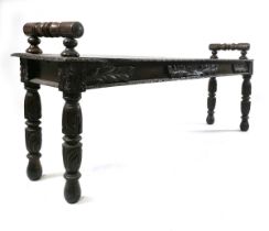 A Victorian carved oak window seat, with turned handles and carved edges above a foliate carved