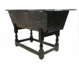 A late 17th/early 18th century oak dough bin, with three plank top, om turned supports united by