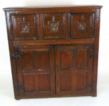 An 17th century and later oak livery cupboard, with three fielded panels with carved floral motif,