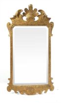 A George II gilt framed mirror, with pronounced foliate terminal flanked by further scrolls and