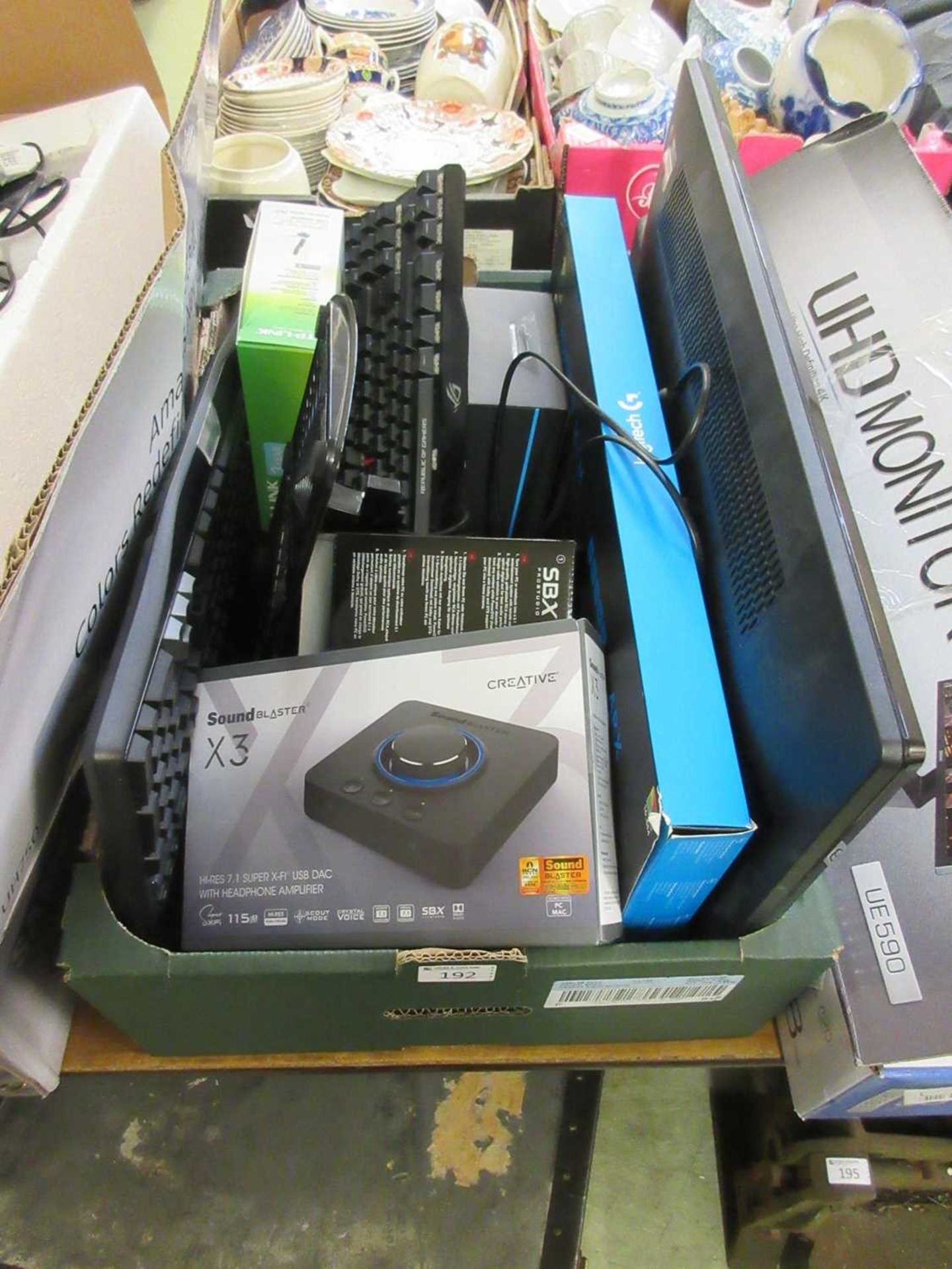 A tray containing keyboards, a computer monitor, sound blaster, etc